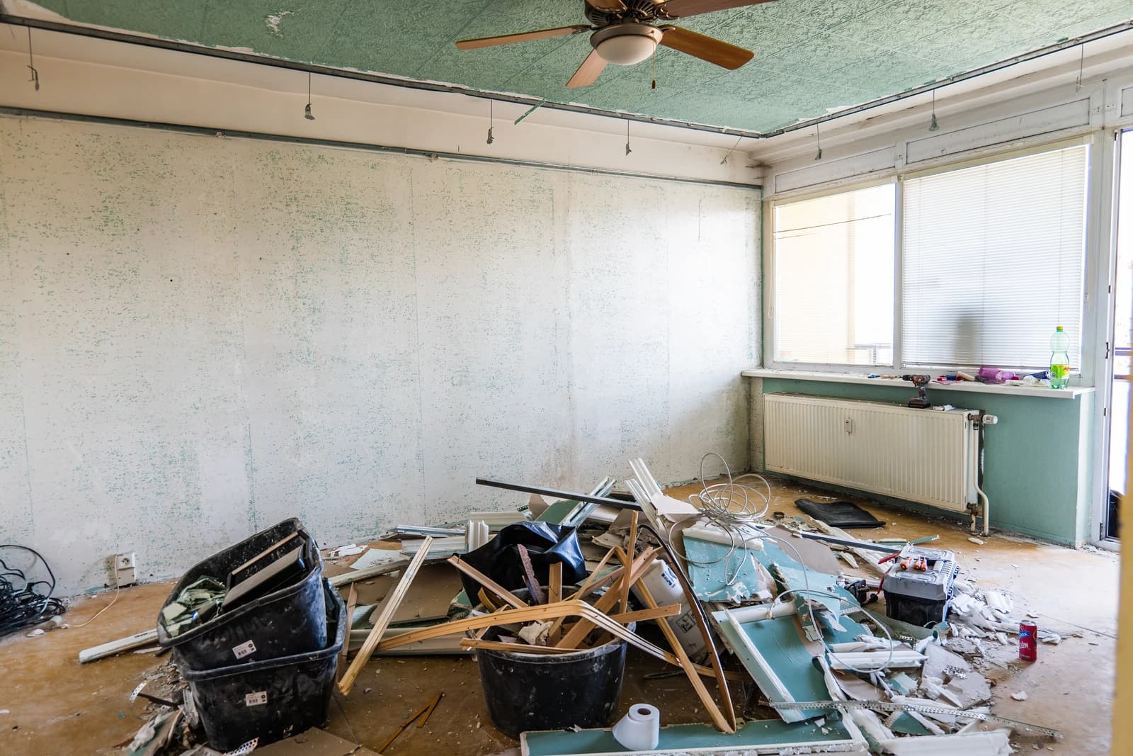 Štýlová tmavá kuchyňa s moderným osvetlením, zlatými akcentmi a elegantným jedálenským stolom.