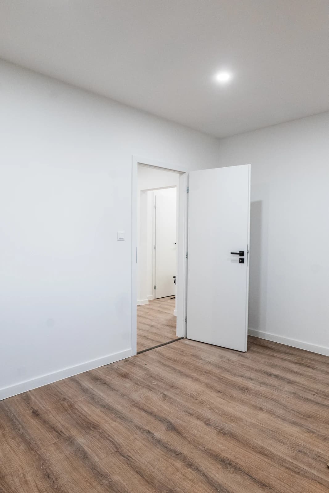 Štýlová tmavá kuchyňa s moderným osvetlením, zlatými akcentmi a elegantným jedálenským stolom.