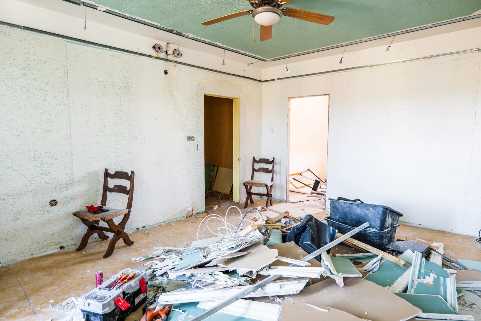 Štýlová tmavá kuchyňa s moderným osvetlením, zlatými akcentmi a elegantným jedálenským stolom.