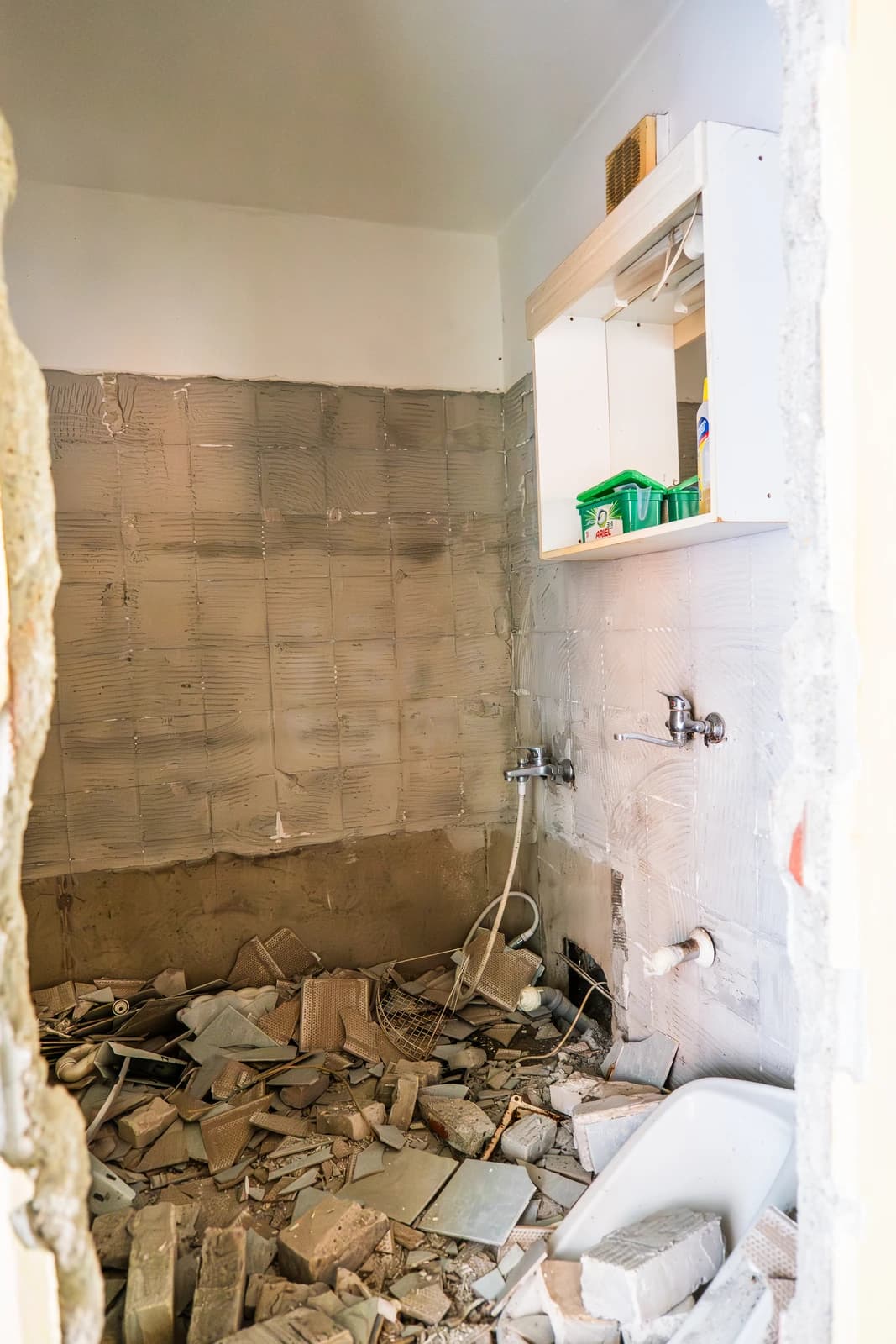 Štýlová tmavá kuchyňa s moderným osvetlením, zlatými akcentmi a elegantným jedálenským stolom.