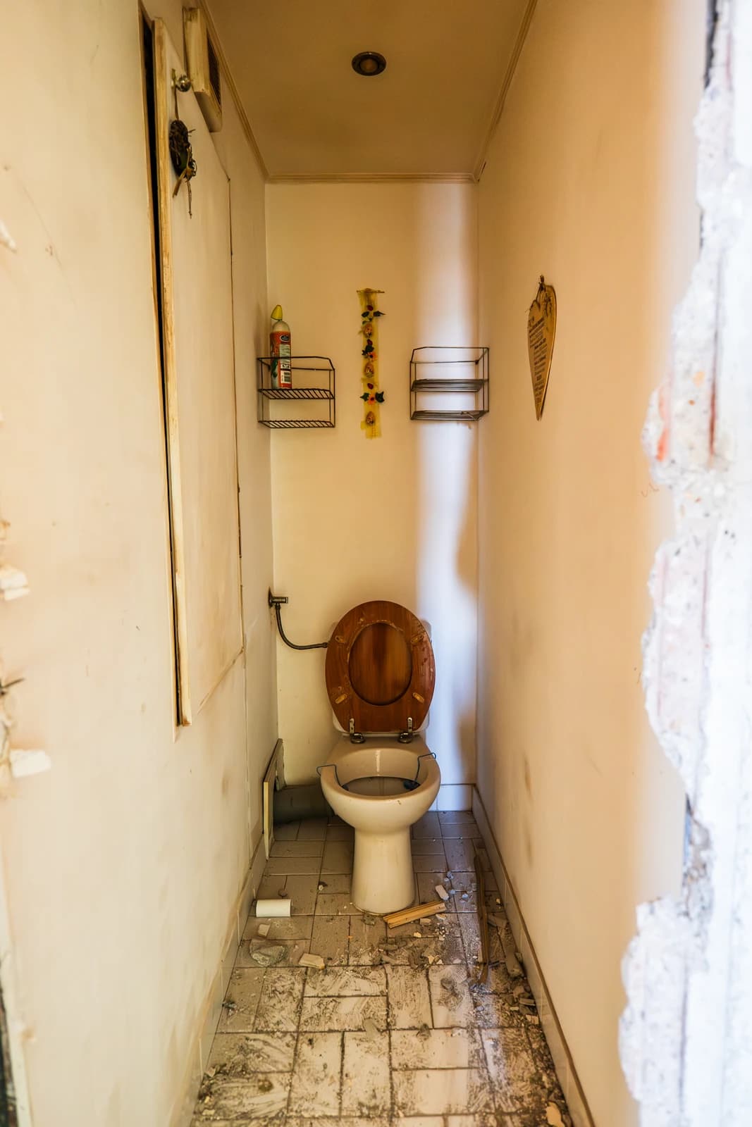 Štýlová tmavá kuchyňa s moderným osvetlením, zlatými akcentmi a elegantným jedálenským stolom.