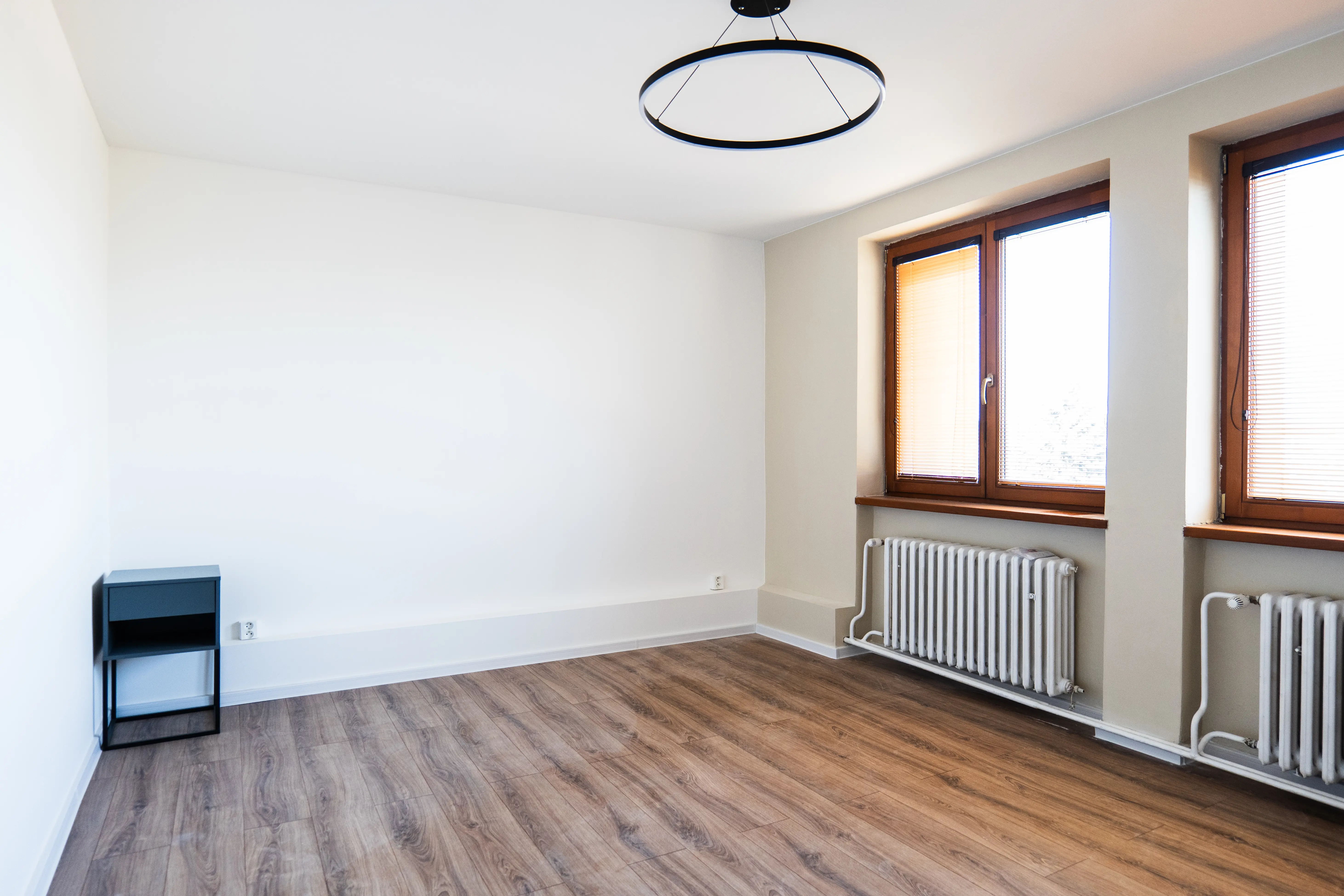 Moderná kancelária v minimalistickom štýle s elegantnými pracovnými stolmi a prírodnými materiálmi.