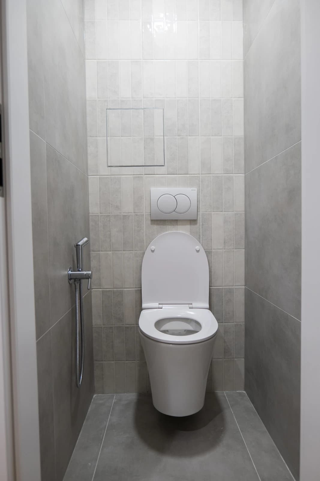 Štýlová tmavá kuchyňa s moderným osvetlením, zlatými akcentmi a elegantným jedálenským stolom.