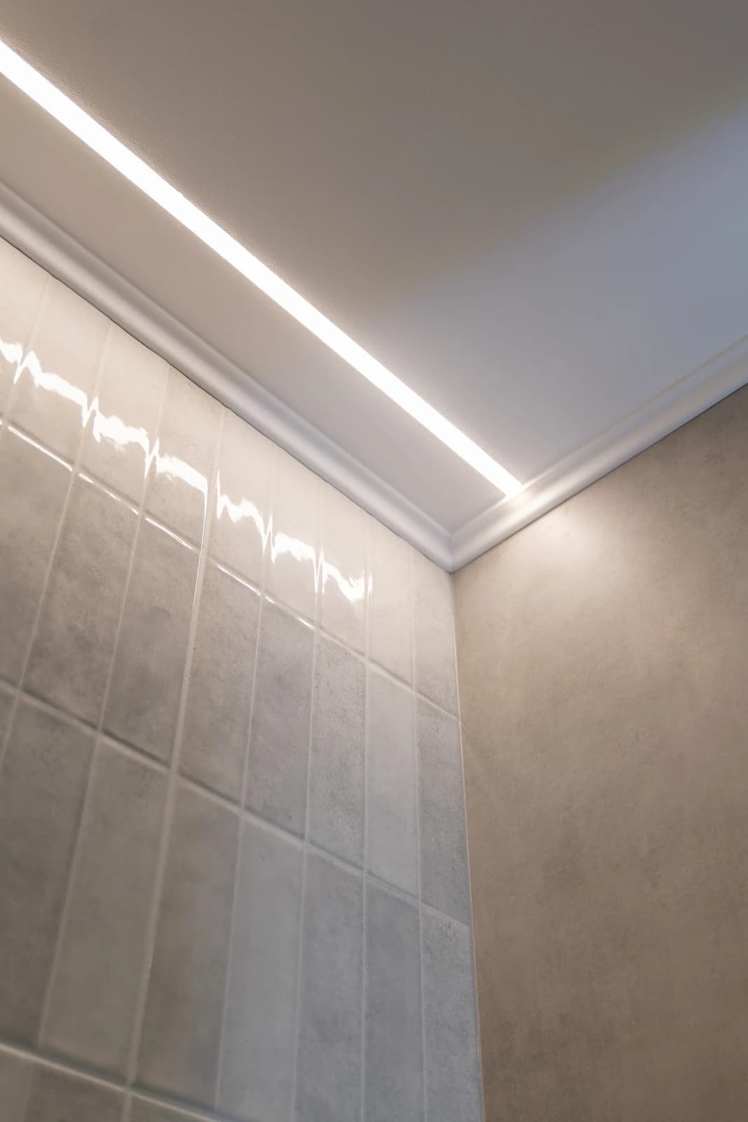 Štýlová tmavá kuchyňa s moderným osvetlením, zlatými akcentmi a elegantným jedálenským stolom.