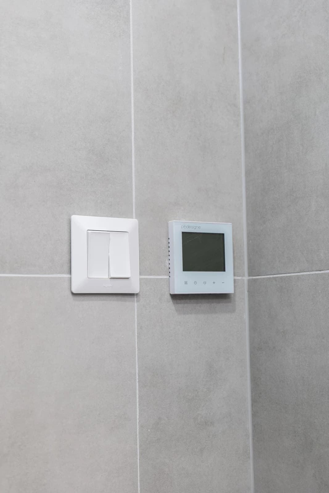 Štýlová tmavá kuchyňa s moderným osvetlením, zlatými akcentmi a elegantným jedálenským stolom.