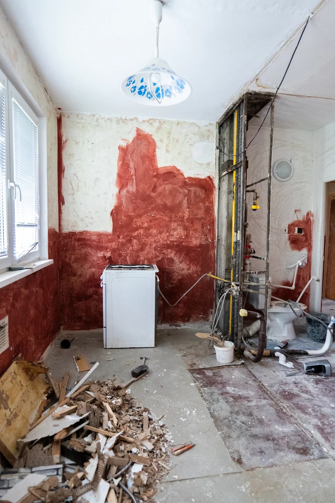 Štýlová tmavá kuchyňa s moderným osvetlením, zlatými akcentmi a elegantným jedálenským stolom.