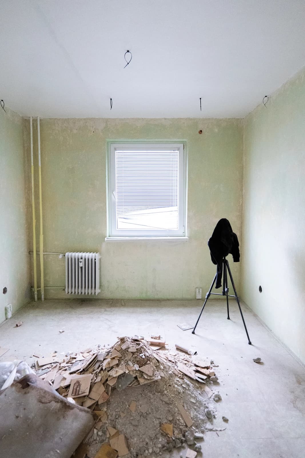 Štýlová tmavá kuchyňa s moderným osvetlením, zlatými akcentmi a elegantným jedálenským stolom.