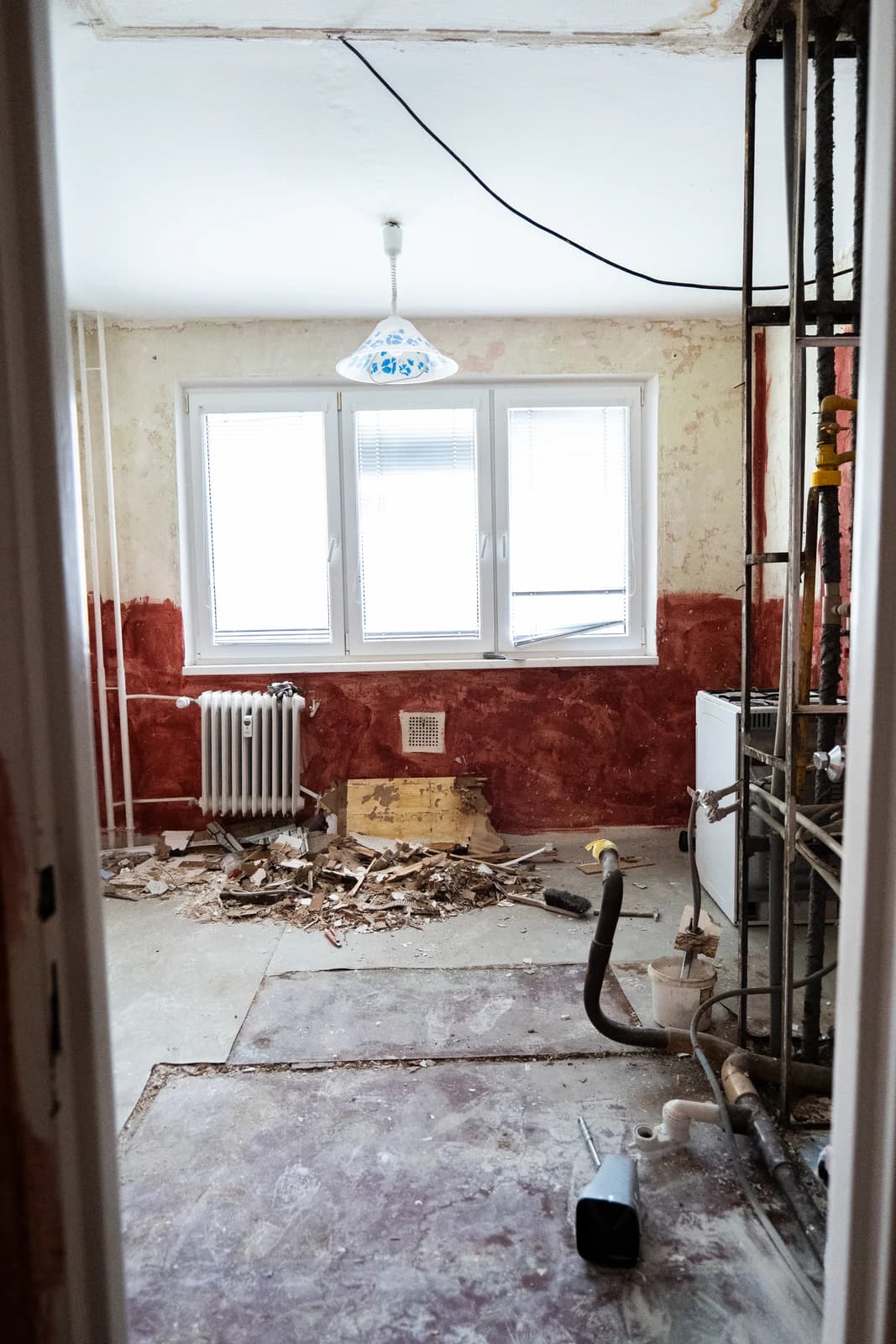 Štýlová tmavá kuchyňa s moderným osvetlením, zlatými akcentmi a elegantným jedálenským stolom.