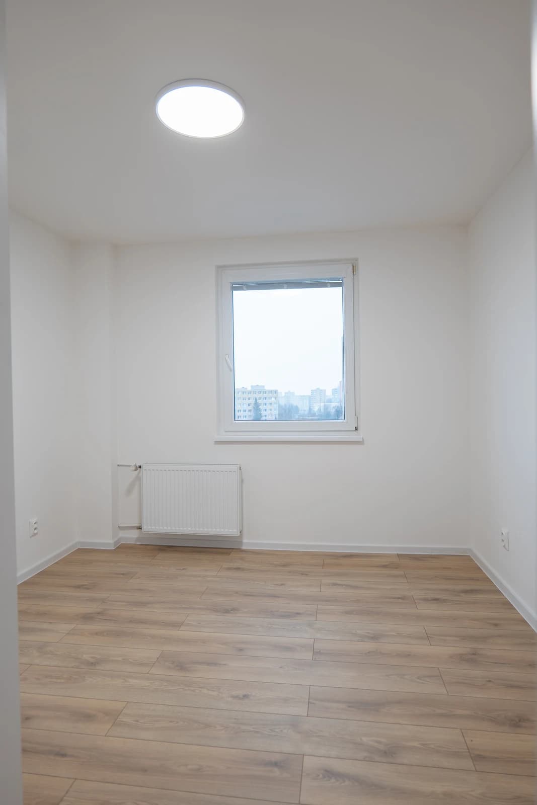 Štýlová tmavá kuchyňa s moderným osvetlením, zlatými akcentmi a elegantným jedálenským stolom.