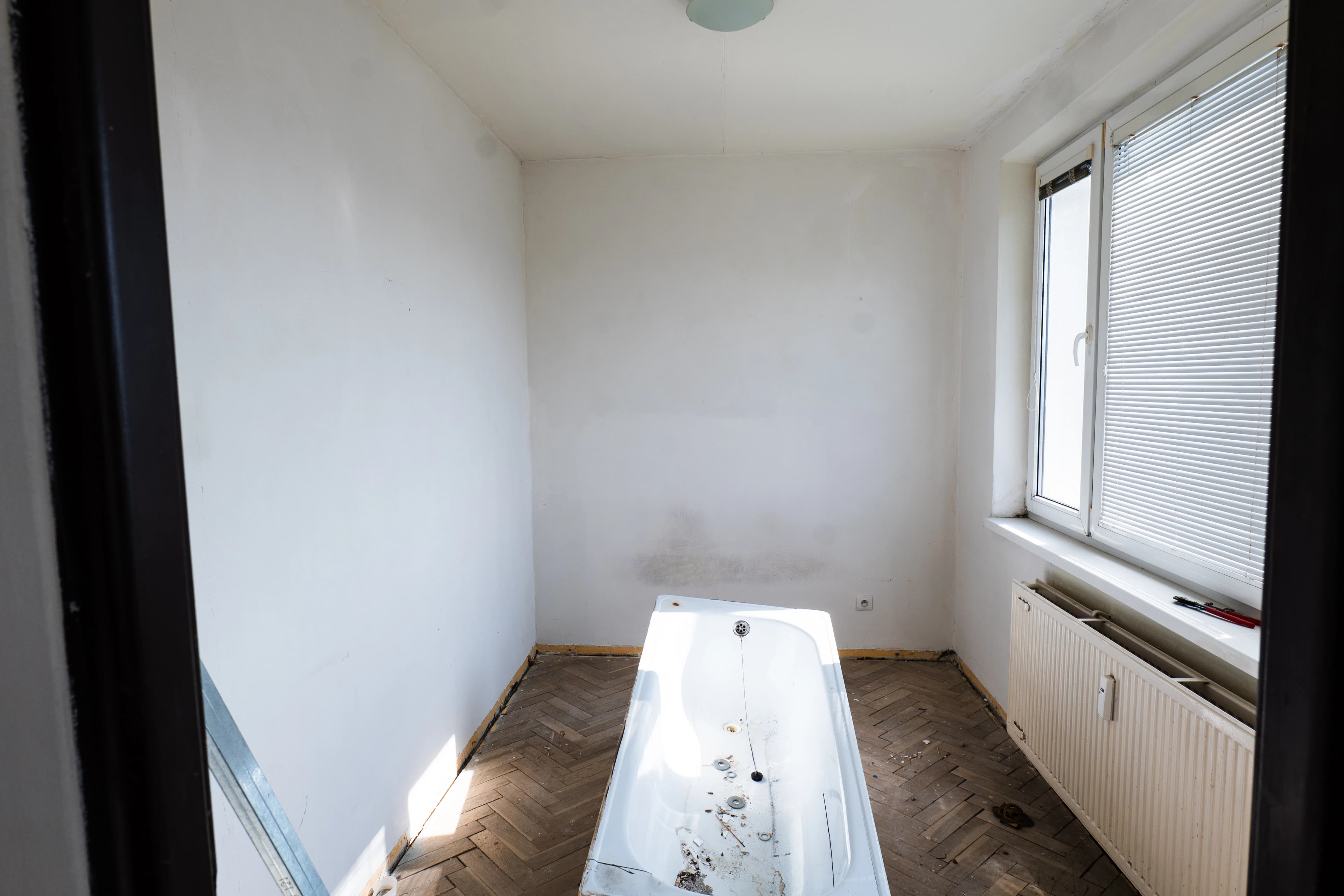 Štýlová tmavá kuchyňa s moderným osvetlením, zlatými akcentmi a elegantným jedálenským stolom.