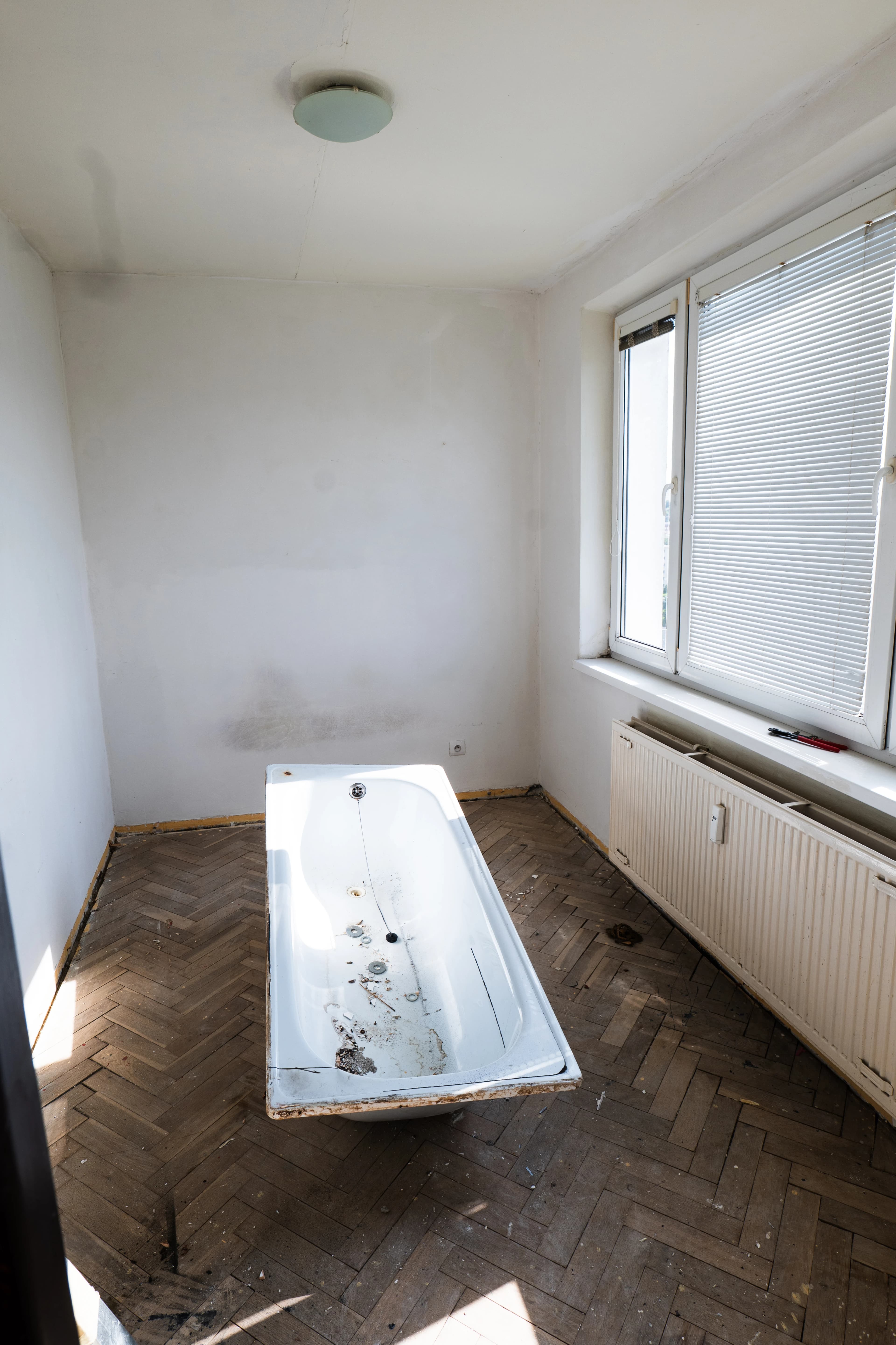 Štýlová tmavá kuchyňa s moderným osvetlením, zlatými akcentmi a elegantným jedálenským stolom.