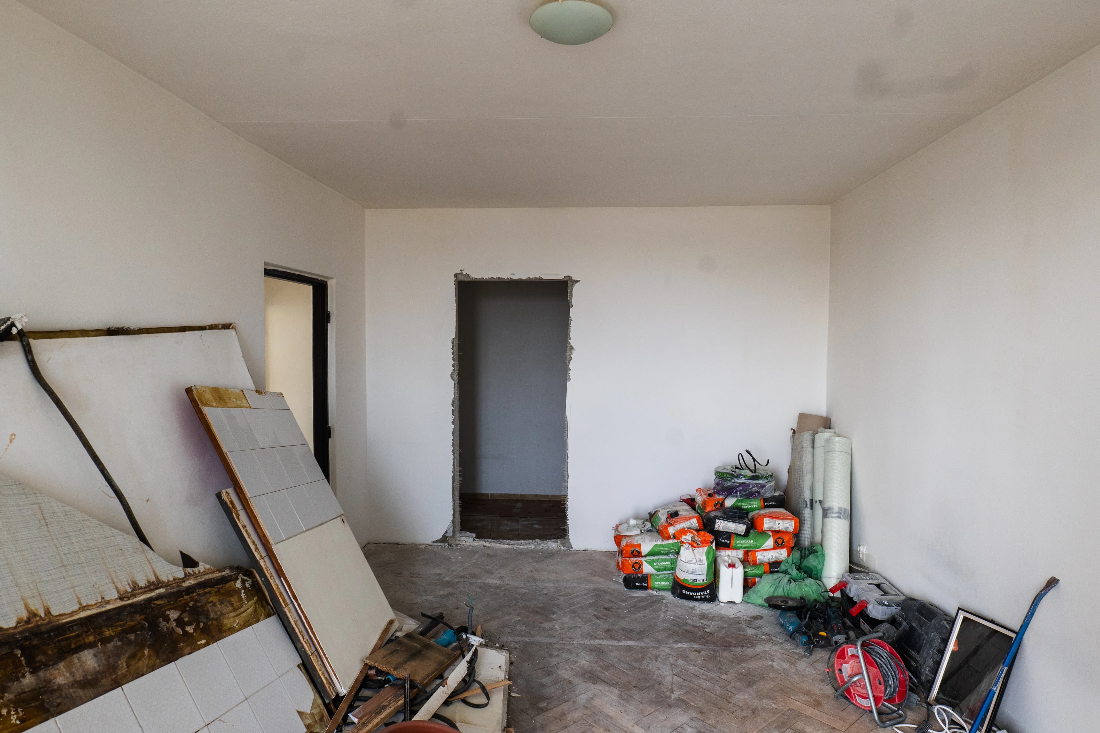 Štýlová tmavá kuchyňa s moderným osvetlením, zlatými akcentmi a elegantným jedálenským stolom.