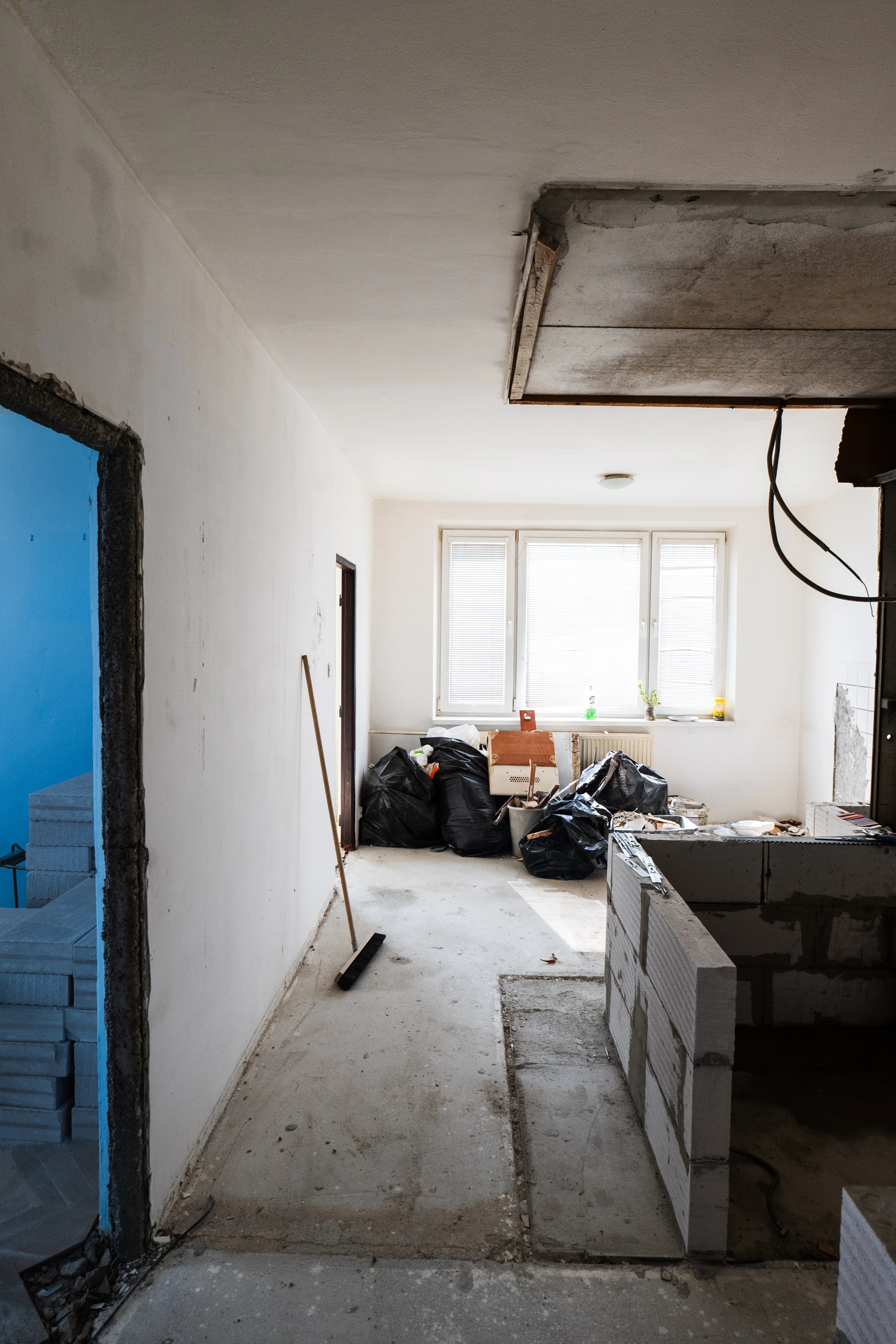 Štýlová tmavá kuchyňa s moderným osvetlením, zlatými akcentmi a elegantným jedálenským stolom.