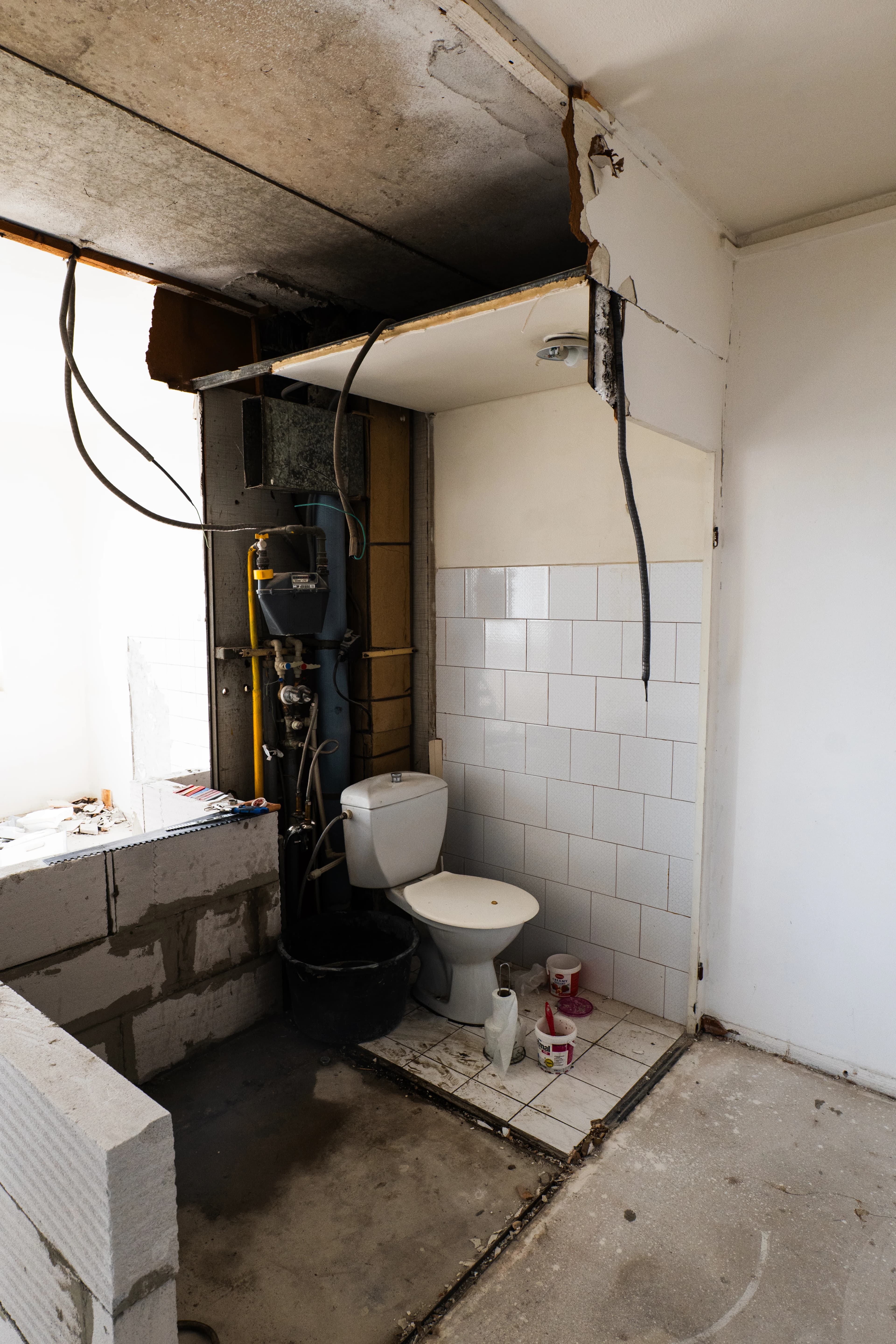 Štýlová tmavá kuchyňa s moderným osvetlením, zlatými akcentmi a elegantným jedálenským stolom.