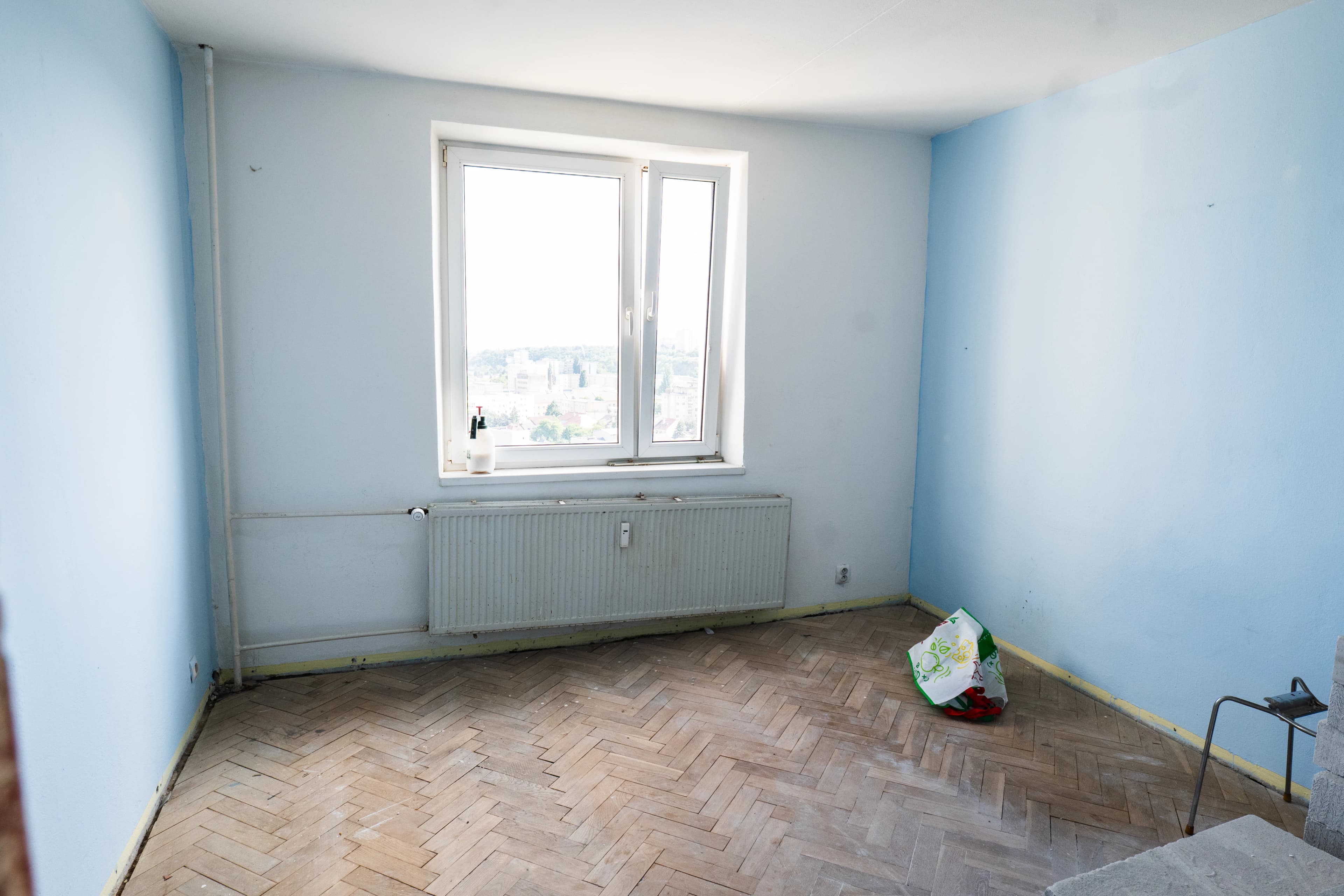 Štýlová tmavá kuchyňa s moderným osvetlením, zlatými akcentmi a elegantným jedálenským stolom.