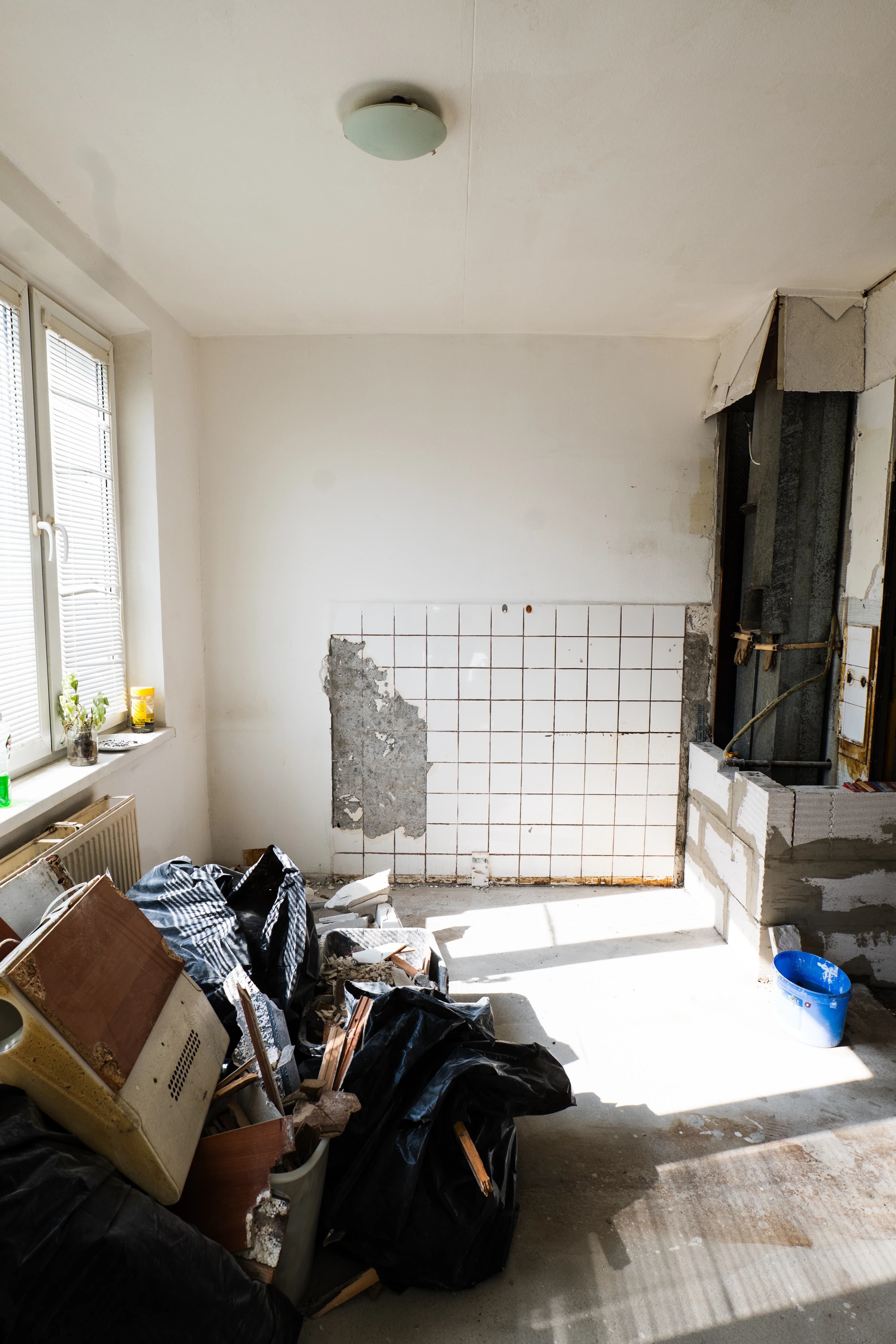 Štýlová tmavá kuchyňa s moderným osvetlením, zlatými akcentmi a elegantným jedálenským stolom.