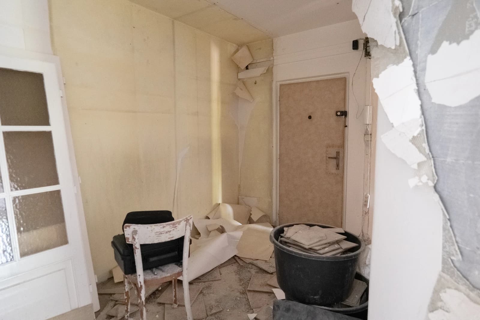 Štýlová tmavá kuchyňa s moderným osvetlením, zlatými akcentmi a elegantným jedálenským stolom.