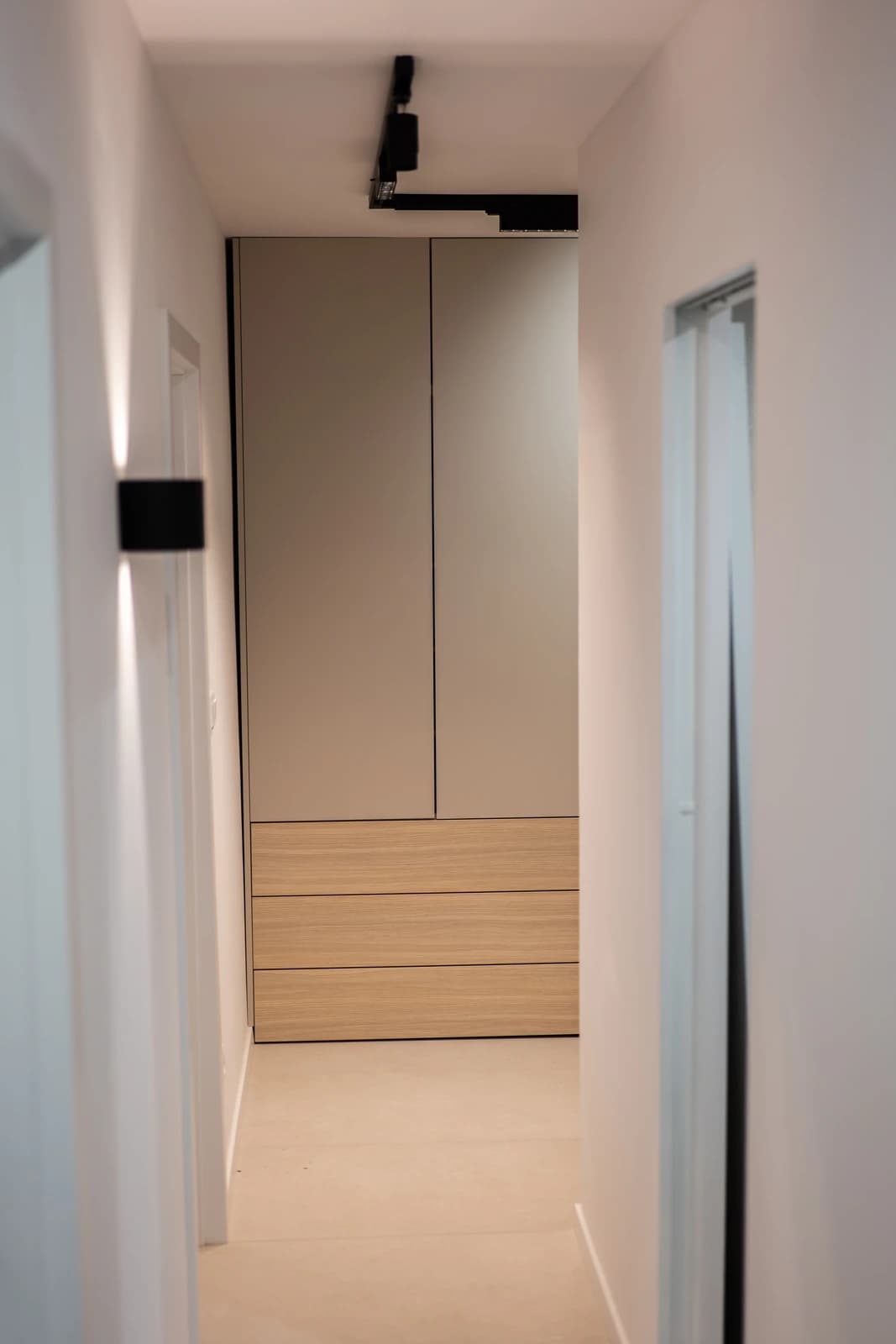 Štýlová tmavá kuchyňa s moderným osvetlením, zlatými akcentmi a elegantným jedálenským stolom.