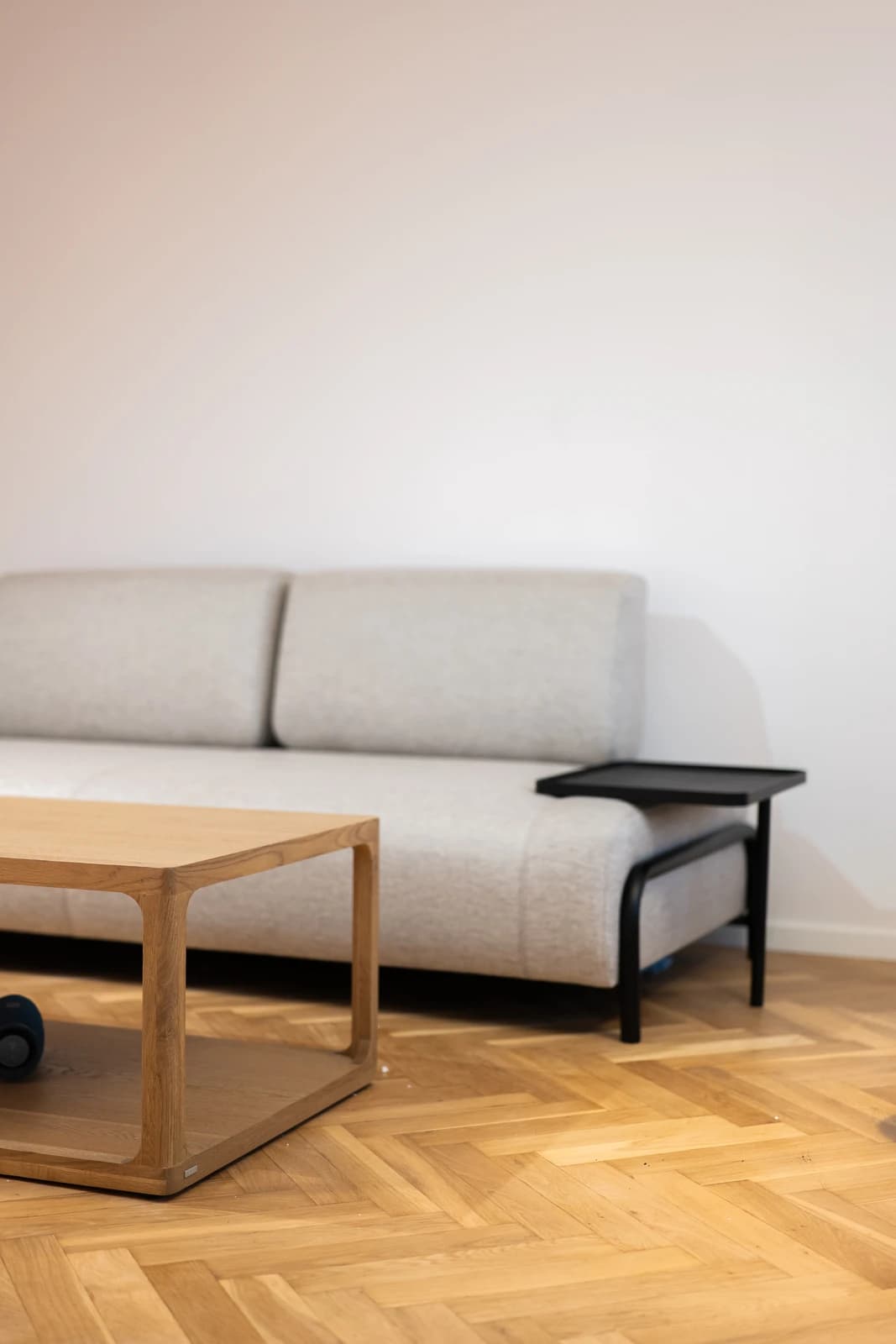 Štýlová tmavá kuchyňa s moderným osvetlením, zlatými akcentmi a elegantným jedálenským stolom.