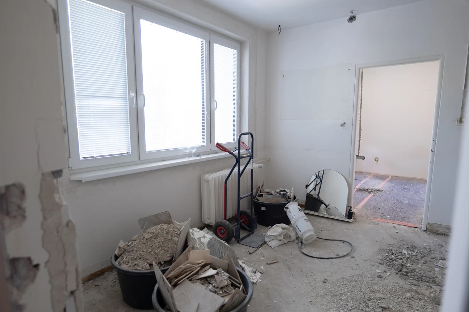 Štýlová tmavá kuchyňa s moderným osvetlením, zlatými akcentmi a elegantným jedálenským stolom.