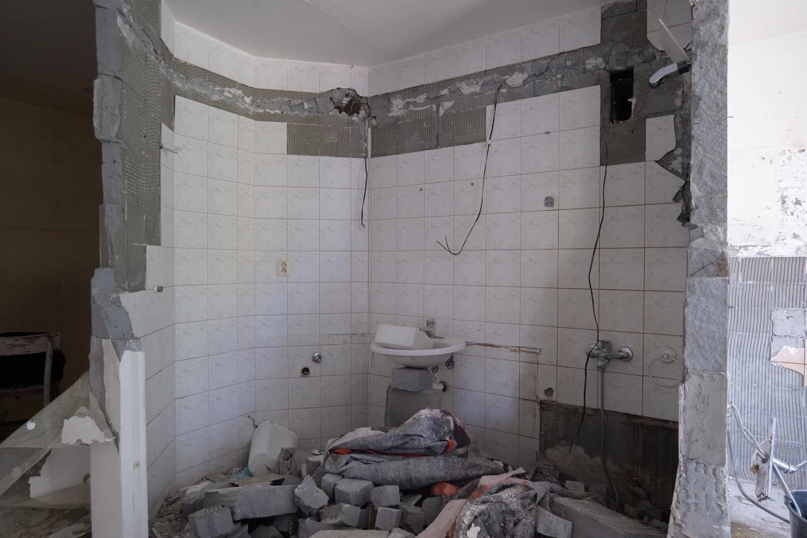 Štýlová tmavá kuchyňa s moderným osvetlením, zlatými akcentmi a elegantným jedálenským stolom.