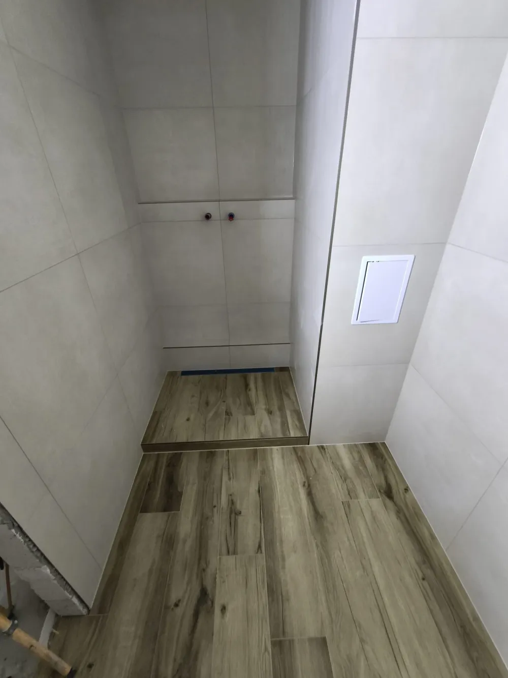 Štýlová tmavá kuchyňa s moderným osvetlením, zlatými akcentmi a elegantným jedálenským stolom.